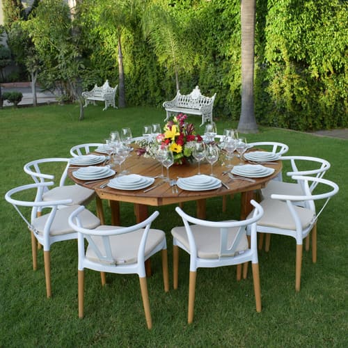 Mesa redonda con sillas blancas en un jardín