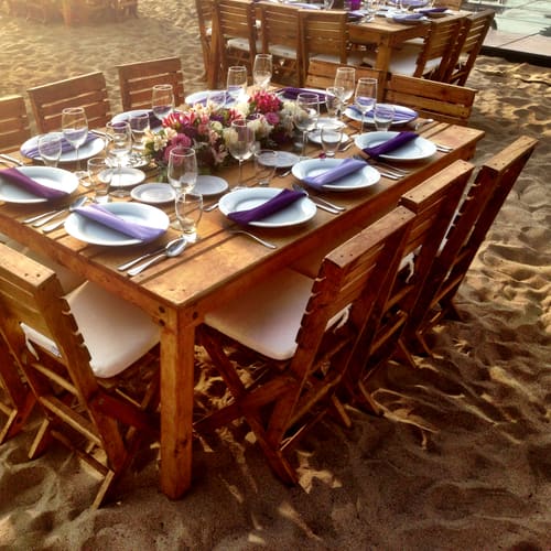 Sillas de madera alrededor de una mesa en la playa